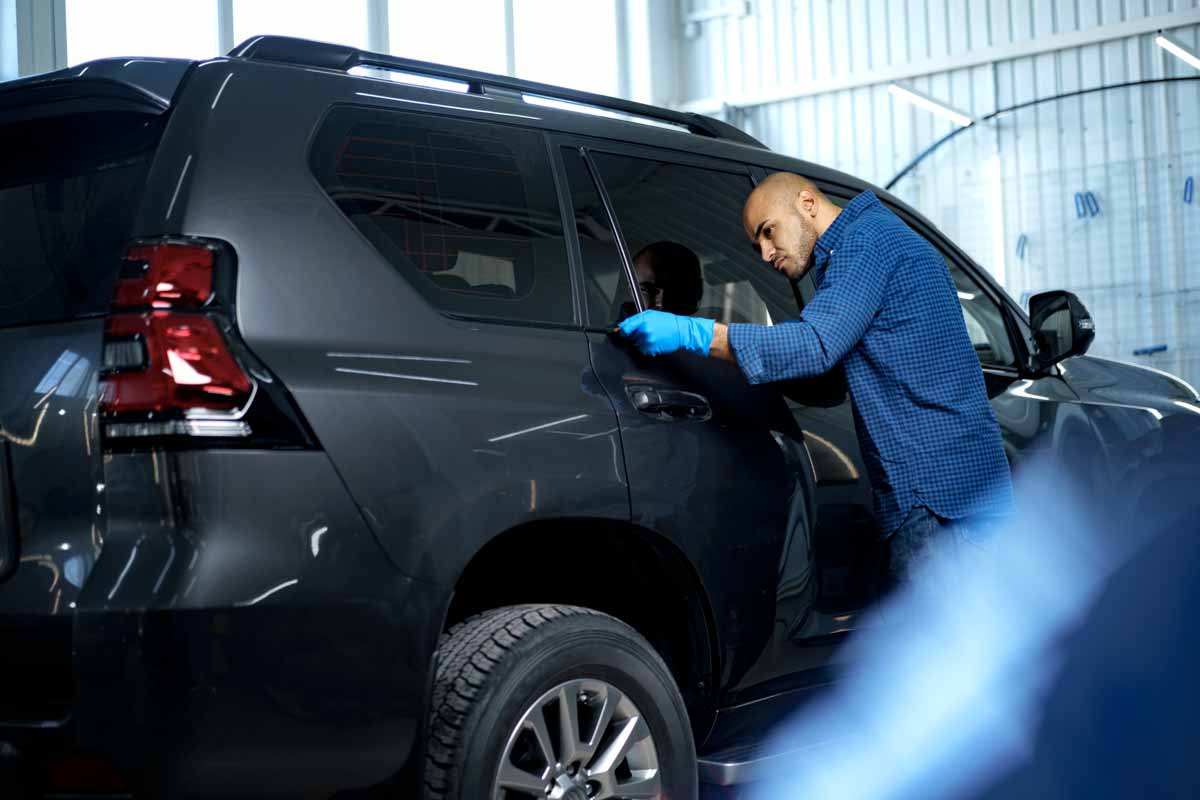 Close up of male car service worker applying nano coating on a car